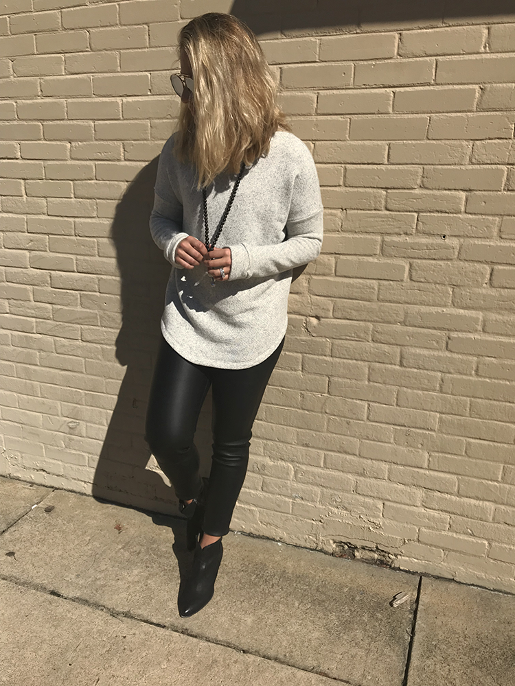 Woman wearing leather leggings and white sweater